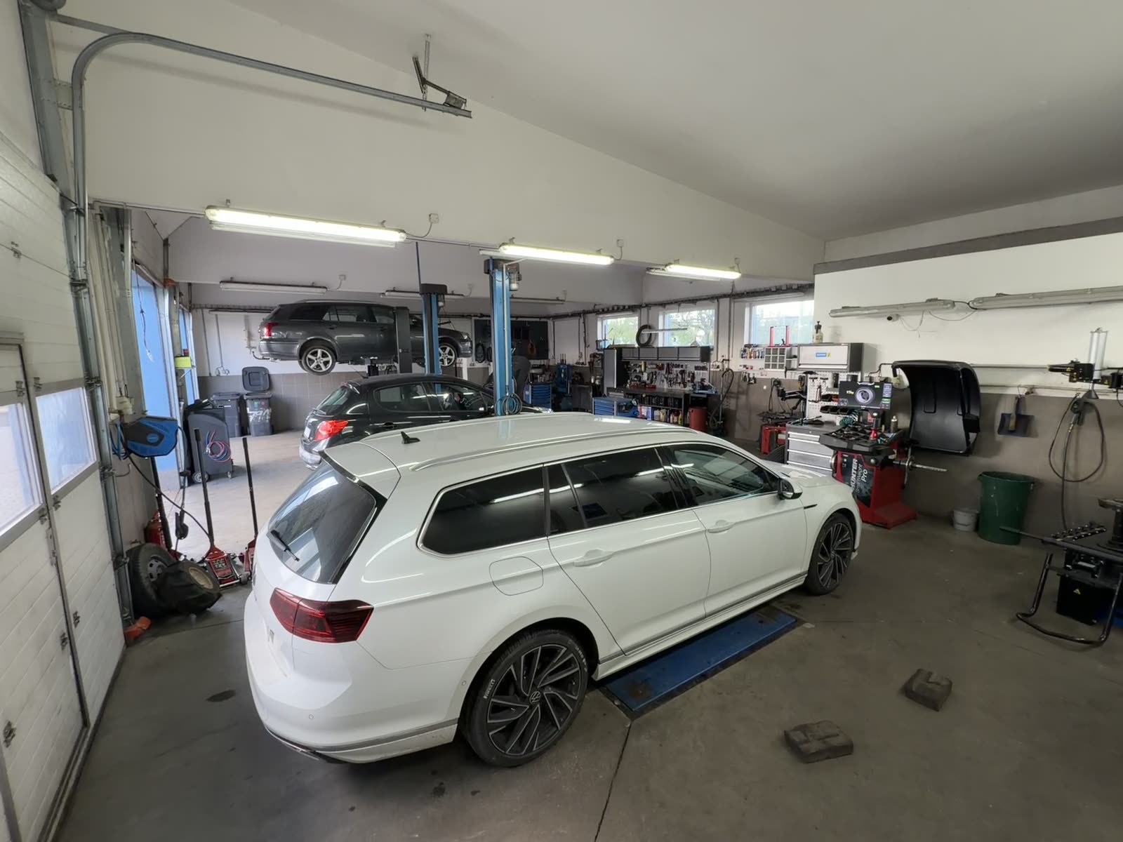 Dílna Hanáček Auto — hala dílny se zvedáky, vůz na stání